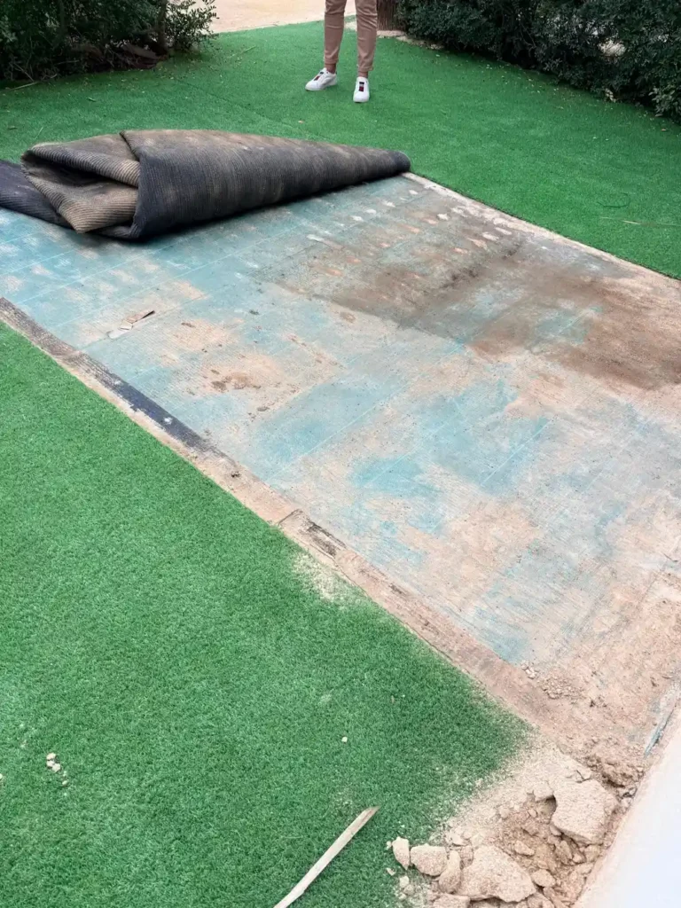 Quitando el césped artificial para fumigar las hormigas